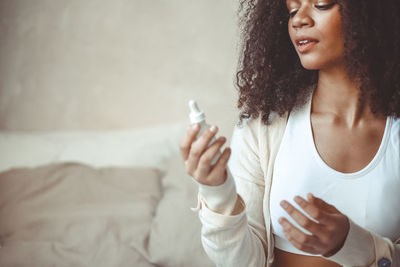 Midsection of teenager girl holding beauty product