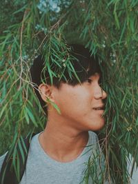 Close-up of young man amidst leaves