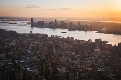 Aerial view of buildings in city during sunset