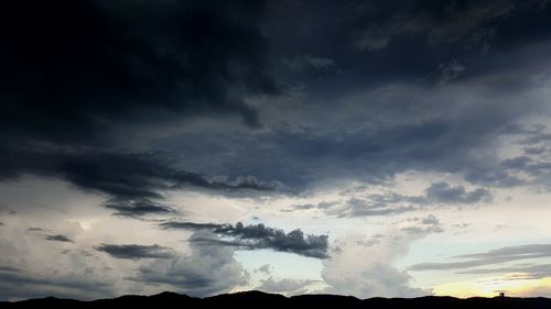 Silhouette of trees against dramatic sky