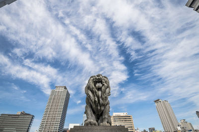 Low angle view of buildings against cloudy sky