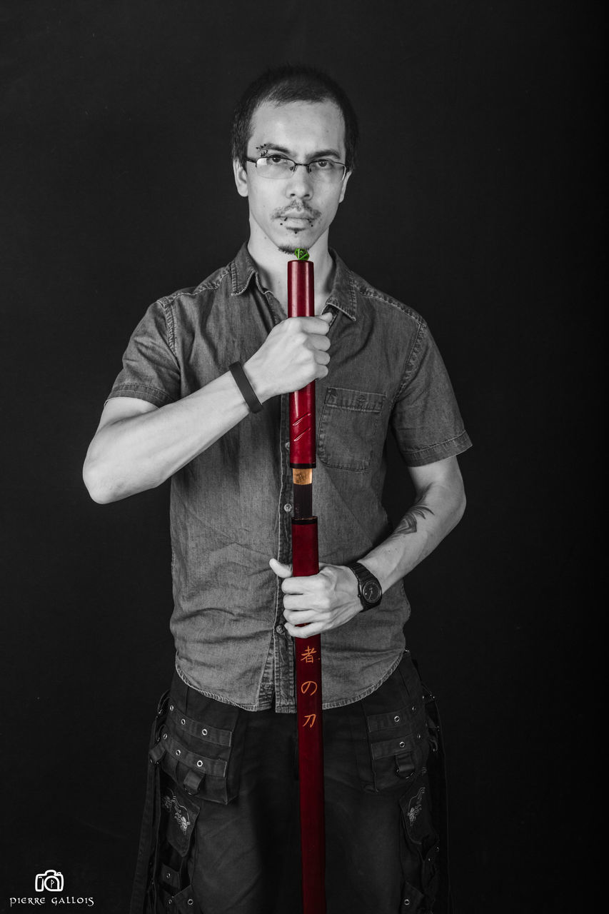 studio shot, front view, looking at camera, one person, three quarter length, standing, real people, red, young men, young adult, lifestyles, portrait, weapon, leisure activity, men, black background, axe