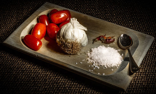 High angle view of tomatoes and vegetables on cutting board
