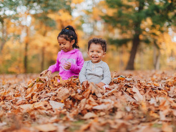 Happy boy with leaves during autumn