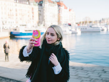 Portrait of young woman holding mobile phone
