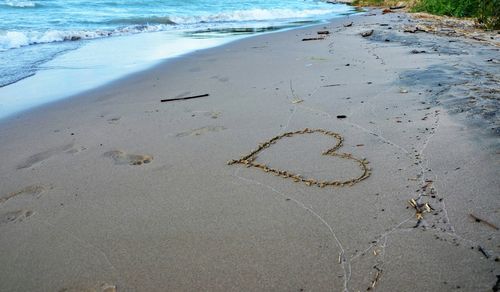 High angle view of heart shape drawn at sea shore