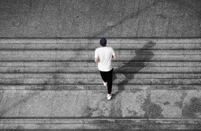 High angle view of man moving up on steps