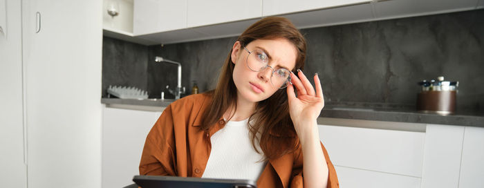 Young woman using mobile phone at home