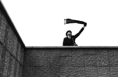 Low angle portrait of man standing against wall