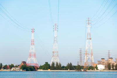 Cranes by river against sky