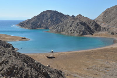 Scenic view of sea and mountains against clear sky