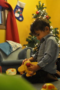Cute boy playing with toys while sitting at home