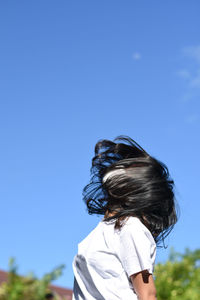 Rear view of woman against blue sky