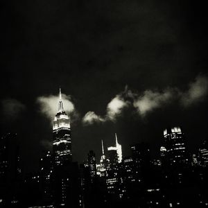 Low angle view of illuminated cityscape against sky at night