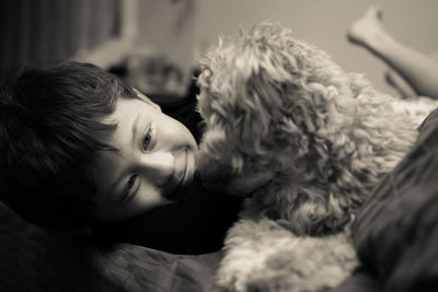 Smiling boy with puppy on bed