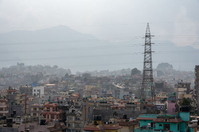 Aerial view of buildings in city against sky