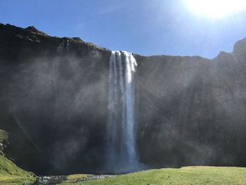 Scenic view of waterfall against sky