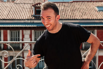 Portrait of smiling man standing against building