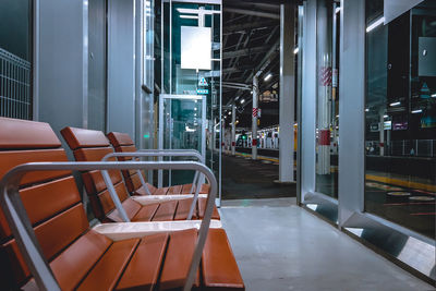 Empty chairs and tables in illuminated building