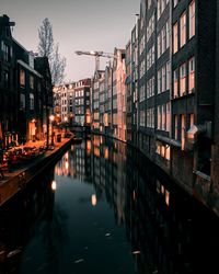 Reflection of illuminated buildings in canal at dusk