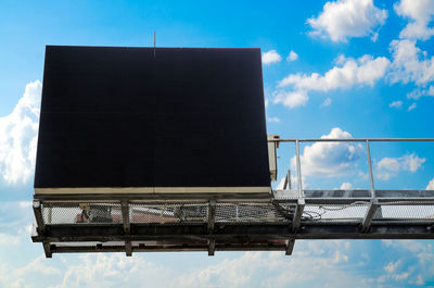 Low angle view of blank billboard against blue sky