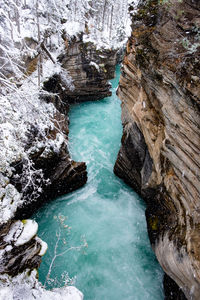 High angle view of water flowing through rocks during winter