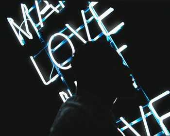 Low angle view of silhouette person with illuminated lights at night