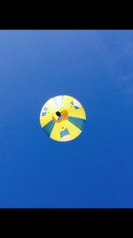 Low angle view of balloons against clear blue sky