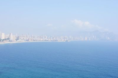 Scenic view of sea and cityscape against sky