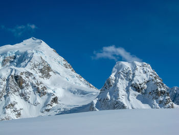 Scenic view of snowcapped mountains against blue sky