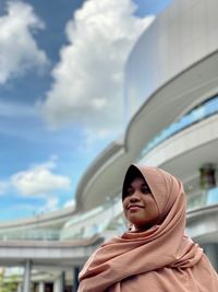 Portrait of woman looking away against sky