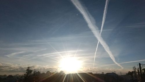 View of vapor trail in sky at sunset