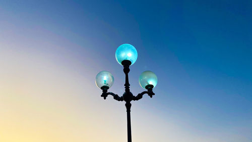 Low angle view of street light against blue sky