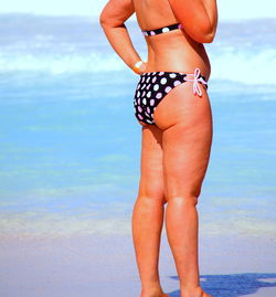 Low section of woman standing on beach