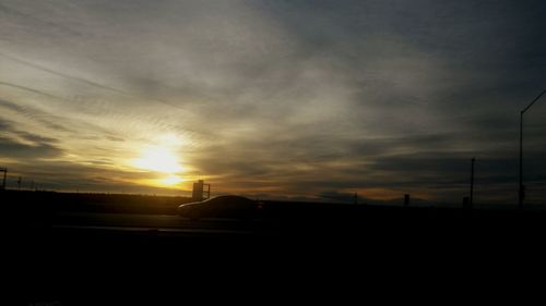 Silhouette of landscape against cloudy sky