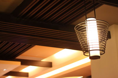 Low angle view of illuminated electric lights hanging from ceiling