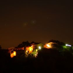 Illuminated city against sky at night