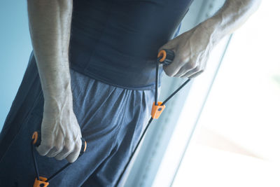 Midsection of man exercising at home