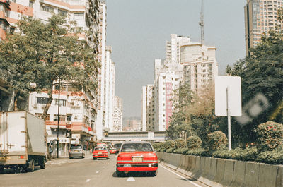 Cars on city street by buildings