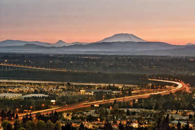 High angle view of illuminated city against sky during sunset