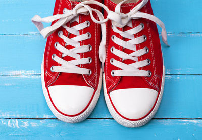 Close-up of red canvas shoes on blue table