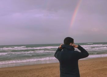 Rear view of man standing on beach