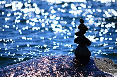 Stacked stones on rock formation by sea