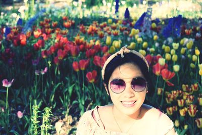 Portrait of smiling woman against flowering plants