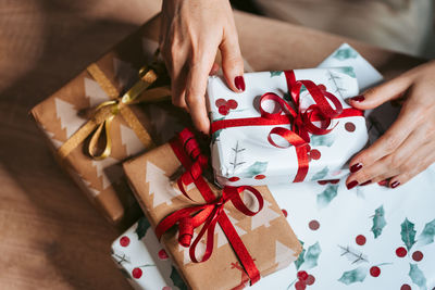 High angle view of woman holding christmas present at table