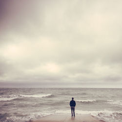 Rear view of man standing at beach