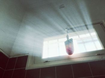 Low angle view of light bulb hanging from ceiling