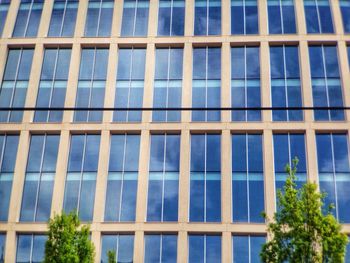 Low angle view of office building against blue sky