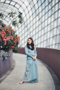 Portrait of smiling woman standing against wall