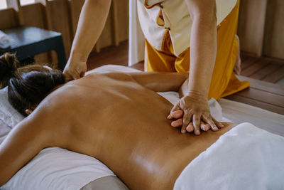 Midsection of man relaxing on bed